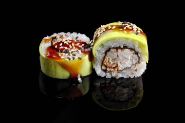 Green dragon sushi roll with eel, avocado and Philadelphia cheese, on a black mirror
