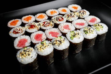 Set of sushi rolls in assortment on a black background