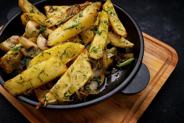 Fried potatoes with mushrooms, onions and dill in a pan