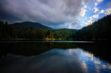 Mountain lake among mountains with reflection, sky with clouds