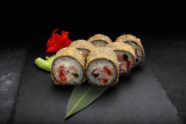 warm sushi rolls with tuna and salmon. on a black stone