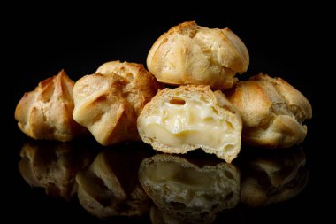 Siyah aynada yansımalı profitroli kekler, yakın plan.