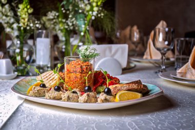 Sebze ziyafeti ve ekmek kızartmaları bir tabakta, masada, bulanık arka planda.