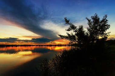 Çarpıcı Bulutlar ve Uzaktaki Şehir Manzaralı Gece Gölü Günbatımı