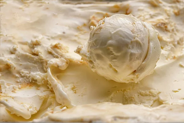 A scoop of ice cream filling with nuts close-up on a background of ice cream filling