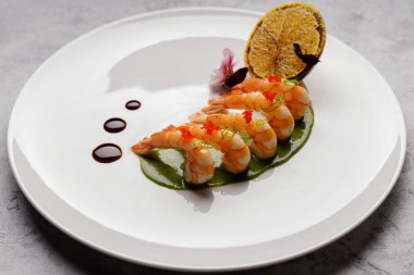 Limonlu taze haşlanmış karides, beyaz tabakta.