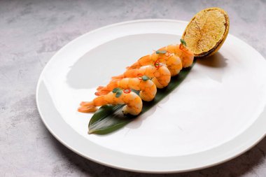 Limonlu taze haşlanmış karides, beyaz tabakta.