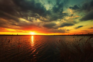 Nehirde sakin bir şafak, nefes kesen renkler ve yansımalarla