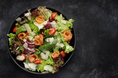 Somon, parmesan, domates ve karışık sebzeli nefis bir salata.