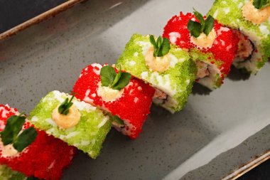 Zarif uçan balık yumurtası ile kaplı nefis suşi rulosu.