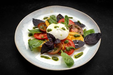 Ağız sulandıran burata peyniri ile birlikte canlı sebzeler ve güzel kokulu otlar vardır.