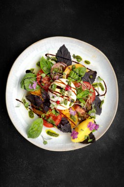 Ağız sulandıran burata peyniri ile birlikte canlı sebzeler ve güzel kokulu otlar vardır.