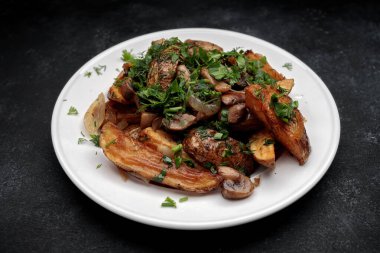 Mantarlı kızarmış patates, soğan, otlar, ev yapımı. Karanlık bir arka planda