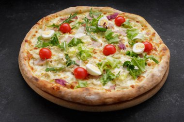 Etli, bıldırcın yumurtalı, domatesli ve otlu pizza Sezar