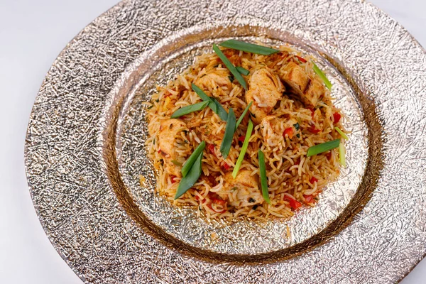 Stock image Oriental pilaf on a plate with chicken, green onions and spices