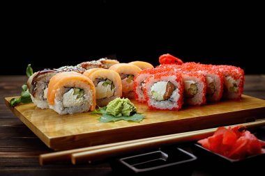 İştah açıcı suşi çeşitleri. Soya sosu, kızıl. tahta arkaplan