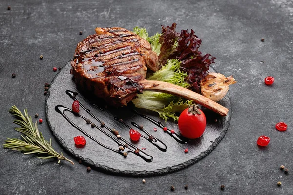 Sült Grillezett Steak Csonton Fokhagymával Paradicsommal Szósszal Fekete Kerek Kövön — Stock Fotó