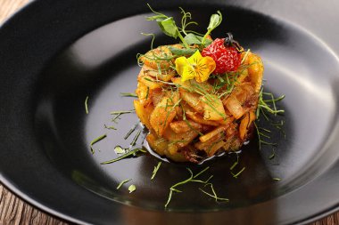 Siyah bir tabak üzerinde otlar ile kızarmış patates