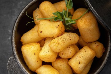 Kızarmış tavuk ısırıkları, dökme demir bir tencerede servis edilir.