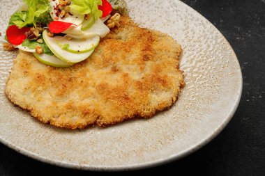 Koyu arkaplanda salatalı biftek.