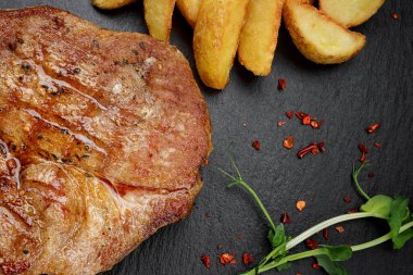 Siyah tahtada biftek ve kızarmış patates.