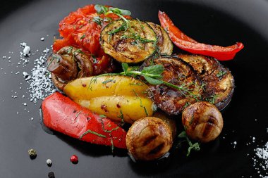 Kömür tabağında ızgara sebze ve mantar.