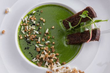 Kremalı ıspanak çorbası, kızarmış ekmek, beyaz tabakta, çuval bezinde.