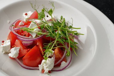 Olgun domatesli renkli bahar salatası, beyaz peynir, soğan ve mikro yeşillik.