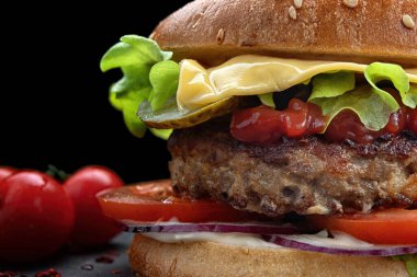 Etli, peynirli, domatesli hamburger. Yaklaş.