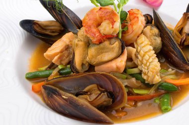 Beyaz tabakta deniz ürünleri salatası.