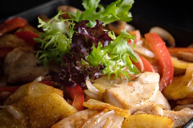 Sebze ve patatesli kızarmış tavuk dilimleri.