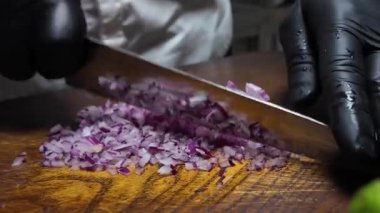 Aşçı soğanı bir tahtada doğruyor.