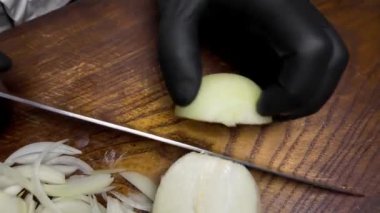 Bir adam ahşap bir yaban domuzunda soğan kesiyor. hd video