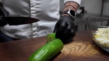 Aşçı taze salatalık keser.