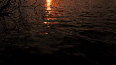 Gölde gün batımı, güneş ışığı ve bulutlar. Yavaş çekim