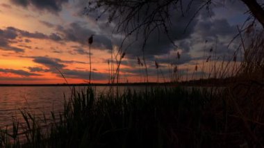 Gölde gün batımı, güneş ışığı ve bulutlar. Yavaş çekim