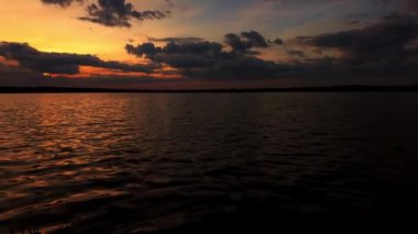 Gölde romantik bir gün batımı, güneş ışığı ve bulutlar. Yavaş çekim