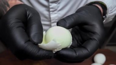 Tahtada haşlanmış tavuk yumurtası soyar.