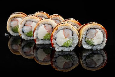 Suşi, karides, krem peynir, yılan balığı ve salatalık. Yansıma ile