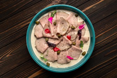 Vitello Tonnato made from thinly sliced pieces of marinated veal seasoned with cream sauce clipart