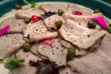 Vitello Tonnato made from thinly sliced pieces of marinated veal seasoned with cream sauce clipart