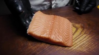 Kesme tahtasındaki tuzlanmış kırmızı balık filetosu.