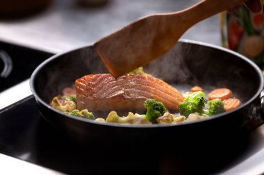 Kızartma tavasında sebzeli kızarmış somon, yakın plan.