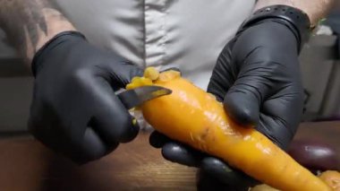 Tahta kesme tahtasındaki haşlanmış havuçları keser.