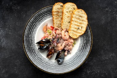 Taze deniz ürünleri, kremalı sos ve kızarmış ekmek karışımı.