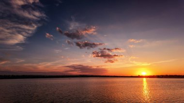Huzurlu göle yansıyan dramatik alacakaranlık bulutları