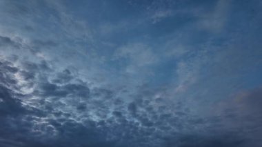 Beyaz bulutların açık mavi gökyüzünde sürüklendiğini gösteren hızlı hareket videosu. Huzurlu ve doğal bir atmosfer..