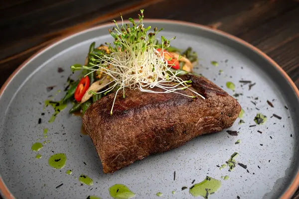 Taze sebze salatasıyla servis edilen sulu etli biftek..