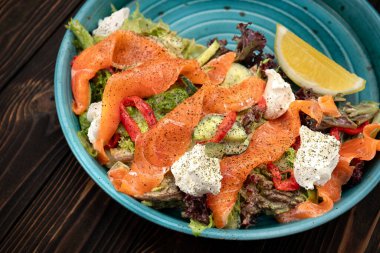 Taze ve canlı salata taze somon, yapraklı yeşillikler ve yumuşak krem peynir karışımı.