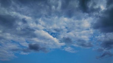 Beyaz bulutların güzel zamanlaması açık mavi gökyüzünde yavaşça hareket ediyor. Metin için alanı olan minimal arkaplan. Doğa, çevre ve iklim temaları için ideal.
